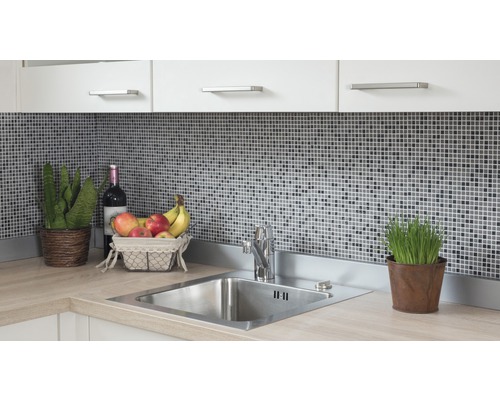 Évier de cuisine avec robinet, carreaux de mosaïque, plantes d''intérieur et corbeille de fruits sur un plan de travail