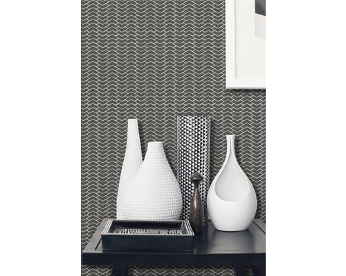 Salon décoratif avec papier peint à motifs, différents vases et un plateau rectangulaire sur une table.