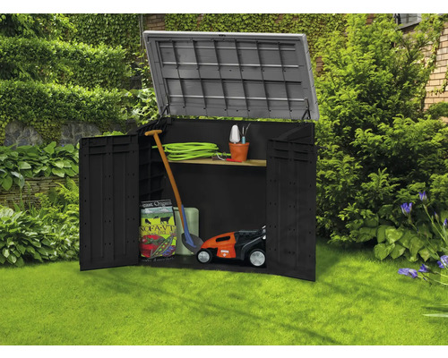 Geöffneter Gartenschrank mit Gartengeräten im Rasen