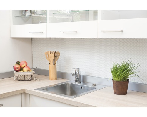 Évier de cuisine avec robinet et ustensiles sur un plan de travail clair