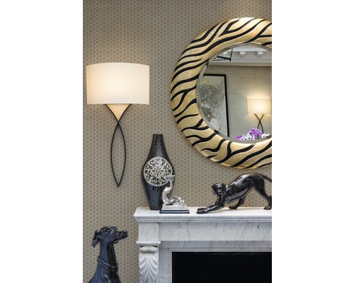 Cheminée décorative avec miroir, lampe et figurines décoratives sur fond de mosaïque.