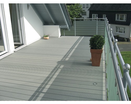 Terrasse avec lames de terrasse grises, rambarde et plantes en pot.