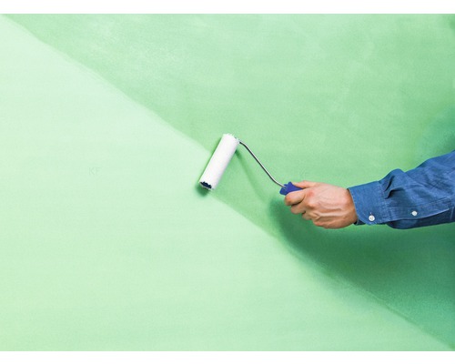 Un mur est peint avec un rouleau à peinture.