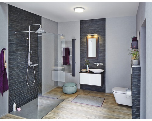 Salle de bains lumineuse avec douche, lavabo, toilettes et plancher en bois