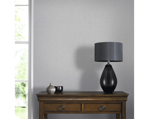 Pièce lumineuse avec papier peint gris, table et lampe