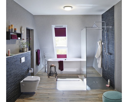 Salle de bains lumineuse avec baignoire, douche, toilettes et fenêtre