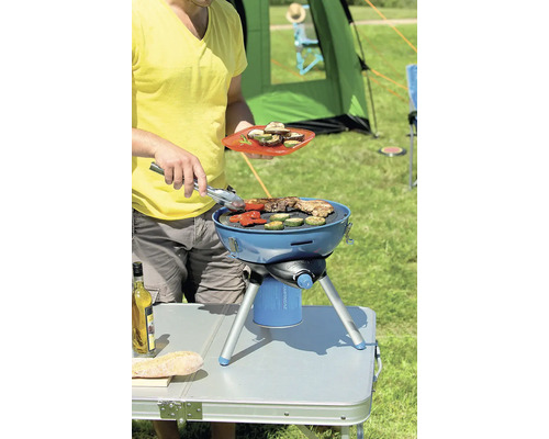 Grill im Betrieb mit Person im Garten