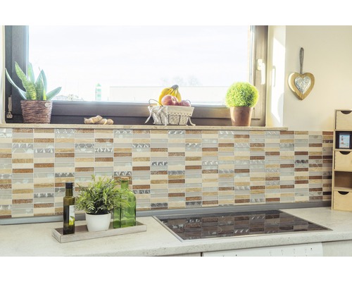 Scène de cuisine avec des carreaux de mosaïque sur le mur, plan de travail avec des plantes et plaque de cuisson