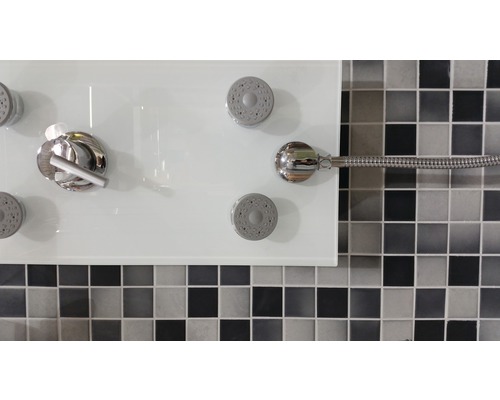 Élément de douche avec plusieurs têtes de douche et robinetterie devant un mur en mosaïque
