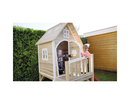 Cabane de jeux en bois avec véranda et deux enfants dans le jardin.