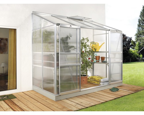 Serre adossée Vitavia Ida 3300 panneaux alvéolés 4 mm 255x132 cm aluminium Serre en métal avec plantes et étagères sur une terrasse en bois