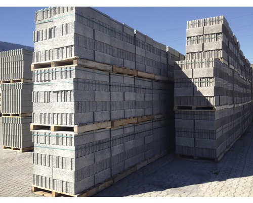 Pile de briques grises sur palettes en bois pour la construction