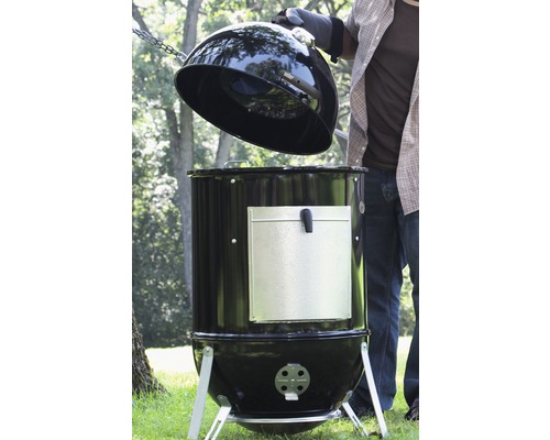 Schwarzer Holzkohle-Smoker mit geöffnentem Deckel für den Aussenbereich