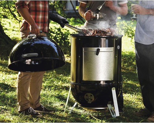 Weber Smoker mit Personen beim Grillen im Garten