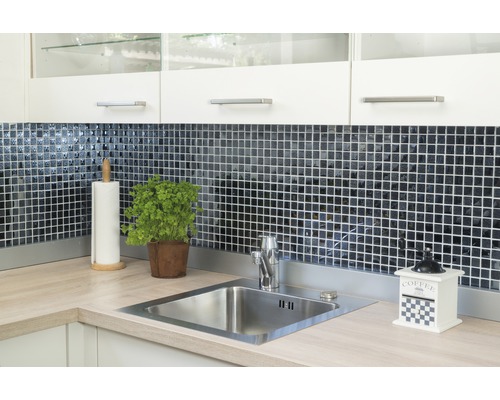 Évier de cuisine avec robinetterie, carrelage, pot d''herbes aromatiques, porte-essuie-tout et moulin à café sur un plan de travail de cuisine