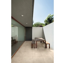 Aussenbereich mit Terrassenplatten, Tisch und Bänken vor einer Hauswand