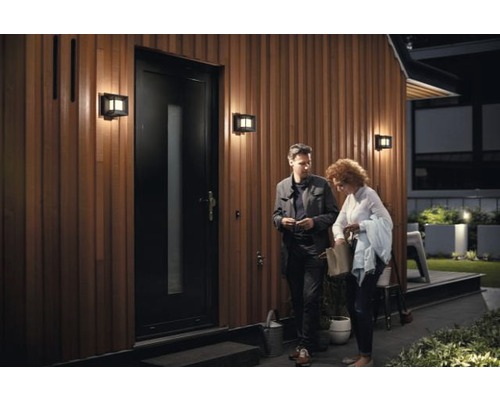 Hausfassade mit Tür, Aussenleuchten und zwei Personen