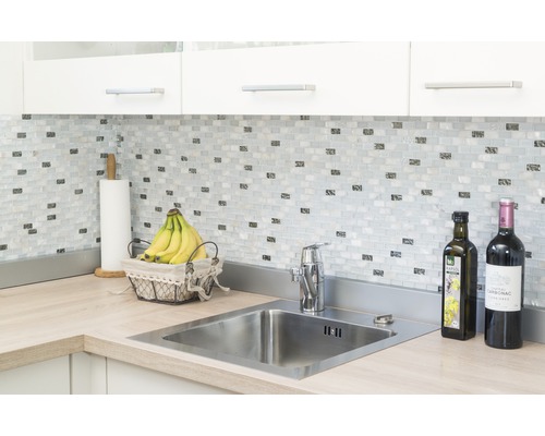 Scène de cuisine avec évier, robinet, carreaux de mosaïque et plan de travail