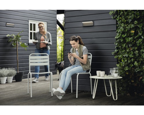 Gartenszene mit Metallstühlen und Beistelltisch auf einer Terrasse