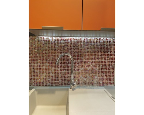 Küchenspüle mit Armatur vor Mosaikfliesen und Hängeschränken