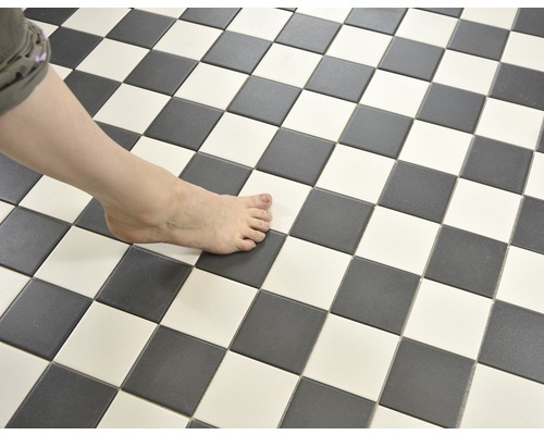 Schachbrettmuster aus Bodenfliesen mit Fuß