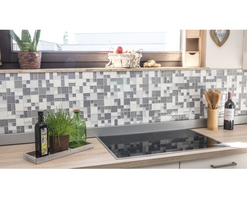 Scène de cuisine avec des carreaux de mosaïque sur le mur et une plaque de cuisson sur le plan de travail.