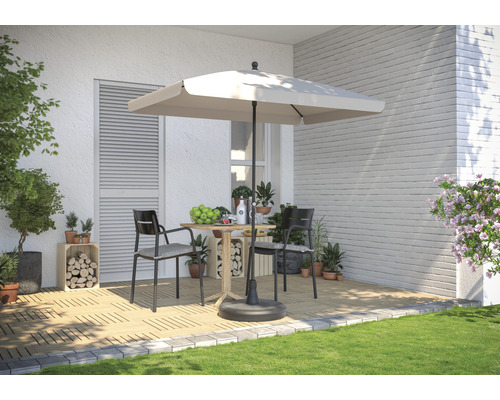 Terrassenszene mit Sonnenschirm, Gartentisch und Stühlen auf Holzboden