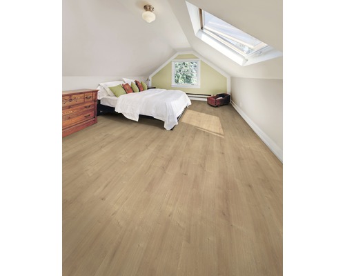 Heller Dachbodenraum mit Laminatboden, Bett, Kommode und Dachfenster.