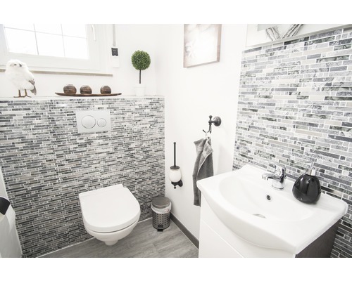 Salle de bains lumineuse avec toilettes, lavabo et carrelage mosaïque