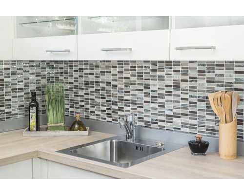 Évier de cuisine avec mur en mosaïque, ustensiles de cuisine et décoration