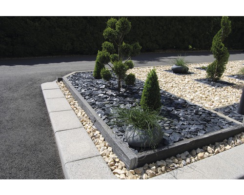 Jardin aménagé avec plantes, pierres et bordures de gazon