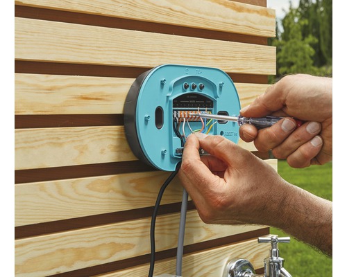 Installation einer Bewässerungssteuerung im Aussenbereich mit einem Schraubendreher