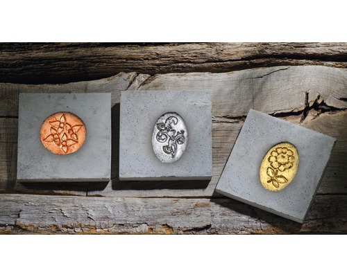 Dekorative Betonfliesen mit verschiedenen Motiven auf Holzgrund