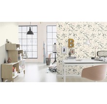 Salon avec papier peint à motifs de feuilles, bureau et étagères pour une ambiance claire et organisée