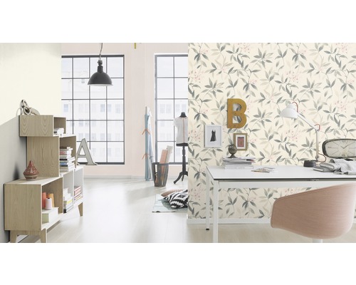 Salon avec papier peint à motifs de feuilles, bureau et étagères pour une ambiance claire et organisée
