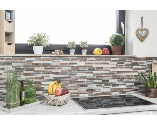 Scène de cuisine avec mur en mosaïque, herbes aromatiques, corbeille de fruits et plaque de cuisson