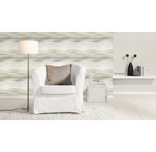 Salon avec papier peint à motifs, fauteuil, lampadaire et décoration