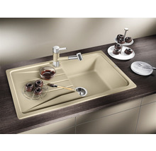 Beige Küchenspüle mit Abtropffläche, Armatur und einigen Backwaren