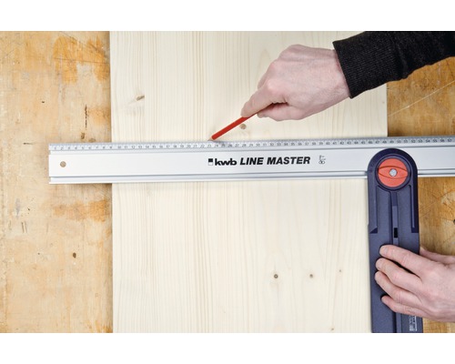 Une main dessine une ligne sur une planche de bois à l''aide d''une équerre