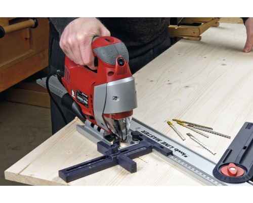 Scie sauteuse électrique en cours d''utilisation avec un rail de guidage sur une planche de bois