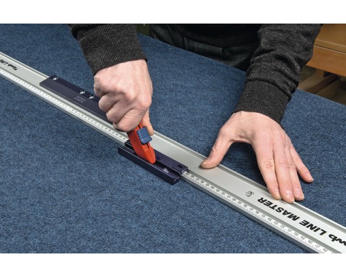 Person schneidet mit einem Rollschneider und Schneidlineal Material