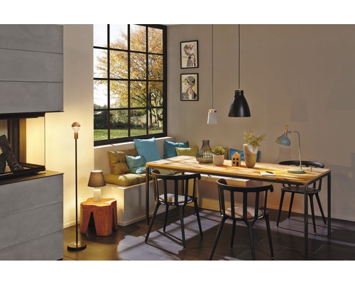 Esszimmer mit Holztisch, Stühlen, Pendelleuchten, Stehlampe und Fenster mit Blick nach draußen