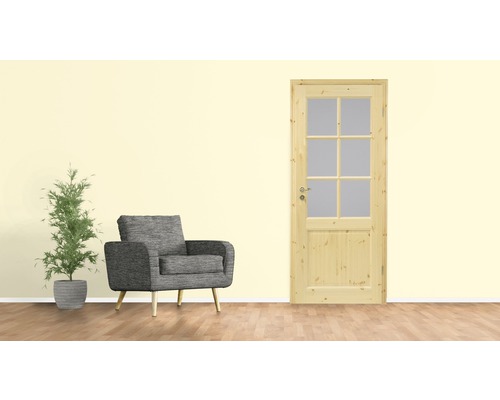 Salon avec porte en bois, fauteuil et plante