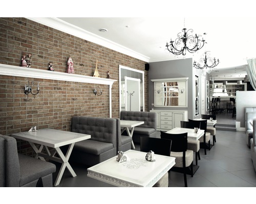 Innenraum eines Restaurants mit Backsteinwand und Sitzgruppen
