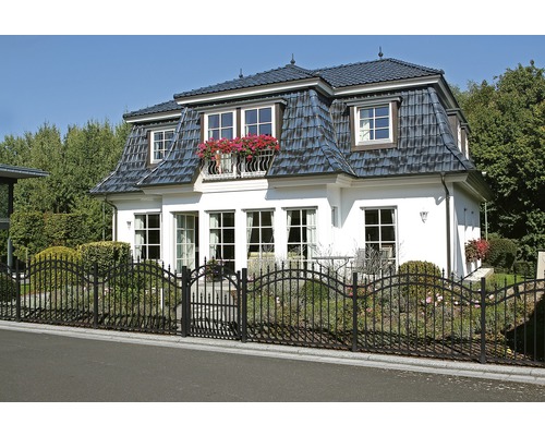 Haus mit Dachziegeln und Metallzaun