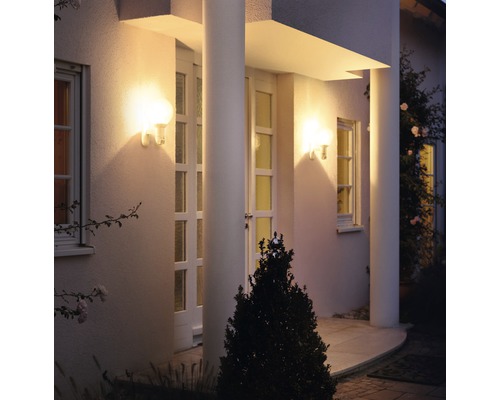 Beleuchtete Hausfassade mit Säulen und zwei Wandleuchten