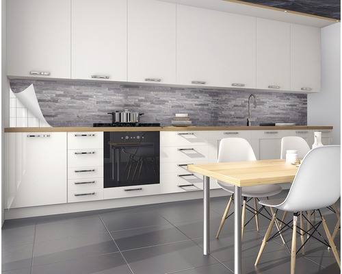 Cuisine moderne avec armoires blanches, plan de travail en bois et mur en pierre grise