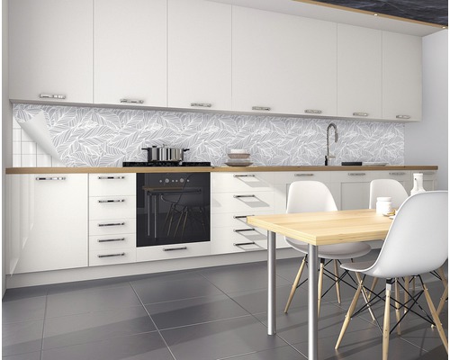 Cuisine moderne avec éléments de cuisine blancs, table à manger et panneaux muraux avec motif de feuilles