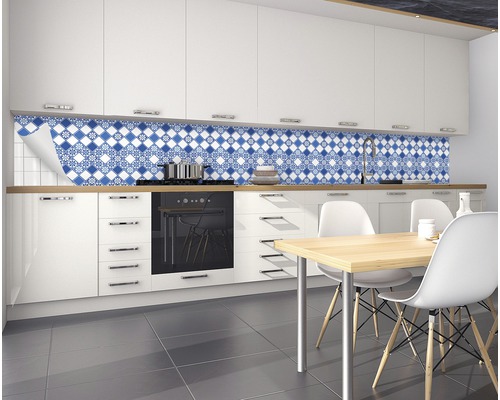 Küche mit weißen Schränken und blau-weißem Fliesenspiegel