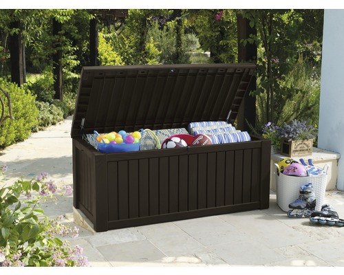 Geöffnete Aufbewahrungsbox aus Kunststoff im Aussenbereich mit Spielzeug und Kissen